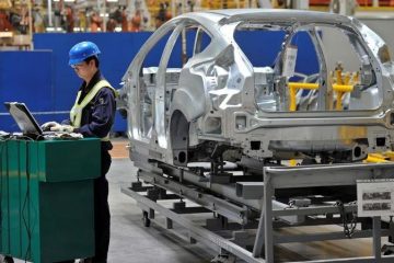 An employee uses a laptop next to a car body at an assembly line at a Ford manufacturing plant in Chongqing municipality April 20, 2012.    REUTERS/Stringer  CHINA OUT. NO COMMERCIAL OR EDITORIAL SALES IN CHINA - RC14E37FAA00